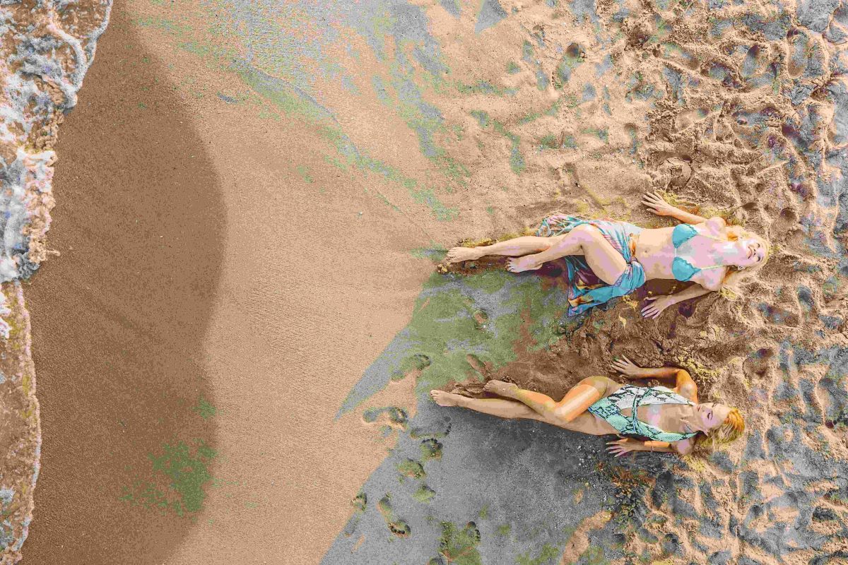top view of two blond girls sunbathing on the sand 2023 11 27 05 05 52 utc scaled